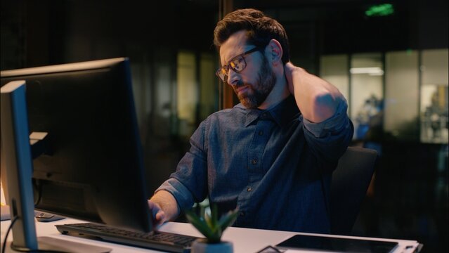 Caucasian man businessman business entrepreneur sedentary computer work syndrome neck ache cervical pain sick tired overworked male guy workaholic discomfort hurt health problem injury in night office