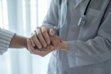 Obraz premium The female doctor uses a friendly hand to hold the patient's hand to give confidence and show care about health care. Medical concepts and good health