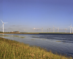 A saturated photo of wind turbines near the Netherlands inner waters in the sunny day, shoot on...