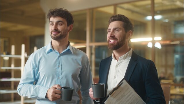 Caucasian men businessmen business partners friendly conversation dialogue talking in office coffee break drinking together guys male co-workers colleagues friends fellows meeting drink tea at company - Powered by Adobe