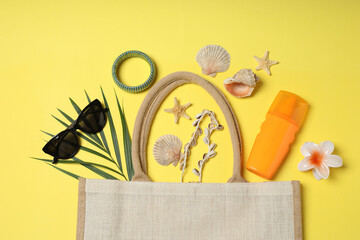 Tropical vibes shot from above. Straw hat, sunglasses, pineapple, wicker bag, beach accessories on...
