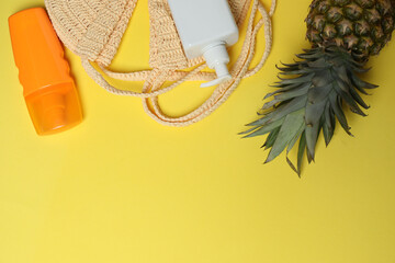 Tropical vibes shot from above. Straw hat, sunglasses, pineapple, wicker bag, beach accessories on...