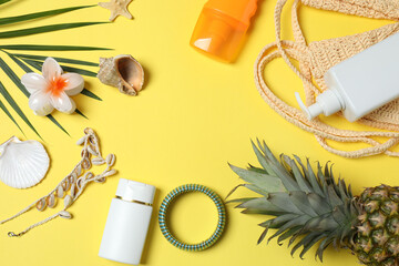 Tropical vibes shot from above. Straw hat, sunglasses, pineapple, wicker bag, beach accessories on...