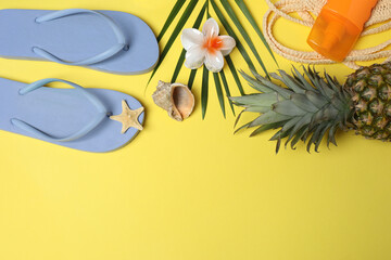 Tropical vibes shot from above. Straw hat, sunglasses, pineapple, wicker bag, beach accessories on...