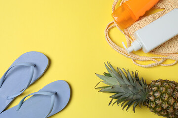 Tropical vibes shot from above. Straw hat, sunglasses, pineapple, wicker bag, beach accessories on...