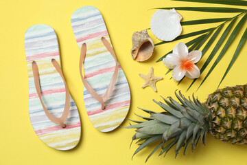 Tropical vibes shot from above. Straw hat, sunglasses, pineapple, wicker bag, beach accessories on...