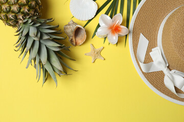 Tropical vibes shot from above. Straw hat, sunglasses, pineapple, wicker bag, beach accessories on...