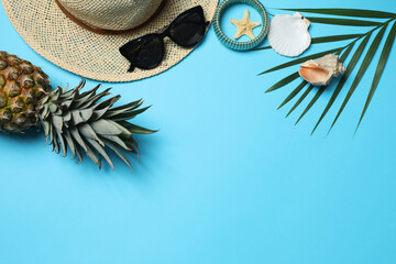 Tropical vibes shot from above. Straw hat, sunglasses, pineapple, wicker bag, beach accessories on...