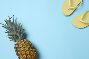 Tropical vibes shot from above. Straw hat, sunglasses, pineapple, wicker bag, beach accessories on...
