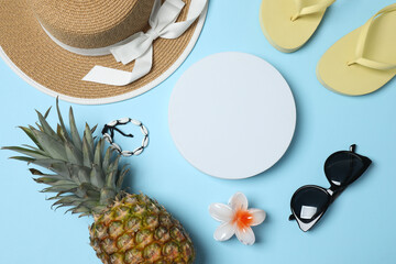 Tropical vibes shot from above. Straw hat, sunglasses, pineapple, wicker bag, beach accessories on...