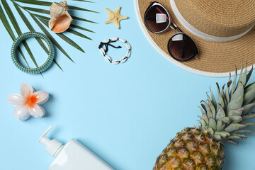 Tropical vibes shot from above. Straw hat, sunglasses, pineapple, wicker bag, beach accessories on...