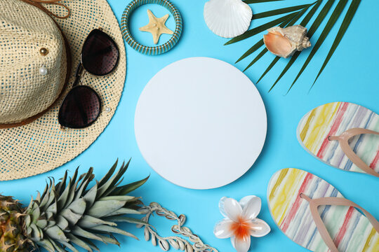 Tropical vibes shot from above. Straw hat, sunglasses, pineapple, wicker bag, beach accessories on a blue background. Perfect for advertising or text overlays