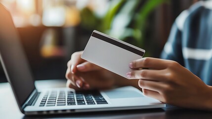 Hands holding blank credit card and using laptop online shopping concept e commerce finance and technology lifestyle setting