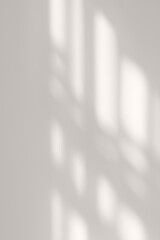 Elegant natural aesthetic backdrop, soft blurred sunlight shadow pattern of windowpane on neutral gray beige plaster wall background