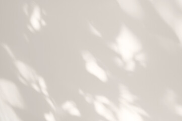 Soft abstract spotty sunlight shadows on neutral light beige plaster wall background, minimal...