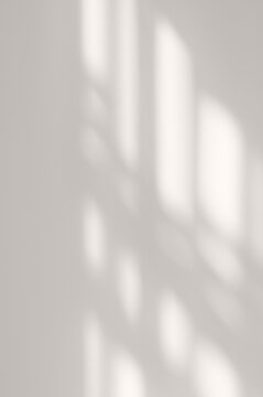 Elegant natural aesthetic backdrop, soft blurred sunlight shadow pattern of windowpane on neutral gray beige plaster wall background