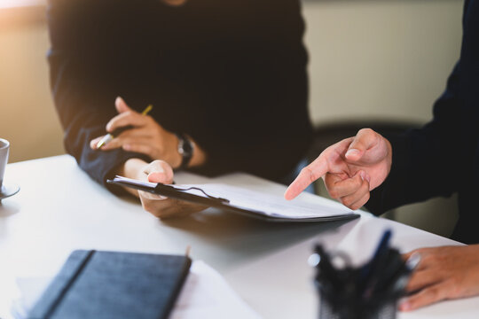 Close up of hands discussing and pointing at document, ready for final approval and signature