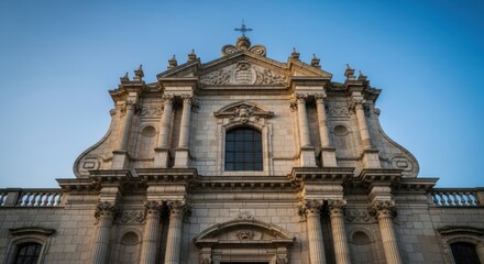 Fototapeta premium Magnificent Baroque Facade of an Ancient Church Bathed in Golden Sunlight Under a Clear Blue Sky