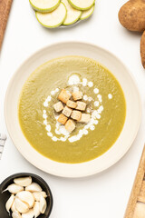 Top view of zucchini, onion and potato hot soup, healthy and vegan food