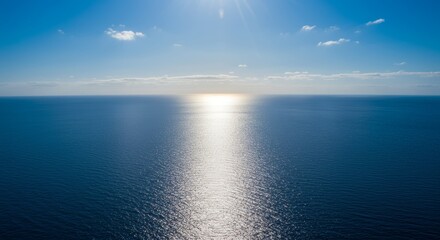 Fototapeta premium Sun-Kissed Horizon: Sparkling Reflection Over a Vast Open Ocean During Daylight