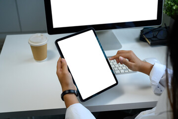 Businesswoman holds a digital tablet with copy space, surrounded by tech accessories