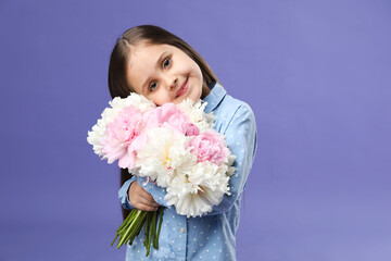 Cute little girl with bouquet of beautiful peonies on purple background