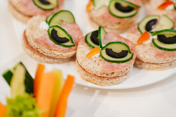 round kid sandwiches in the form of an owl on the served festive table