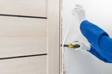 the master cuts off excess mounting foam after installing the doorway