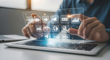 Close-up of hands interacting with a digital interface showing marketing icons like ads, Wi-Fi, data analysis, and social media, highlighting modern digital marketing strategies.