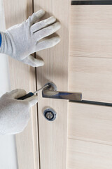 the master tightens the screw for installing the interior lock with a screwdriver