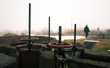 Old water treatment plant showcasing rusted valves and foggy surroundings in a neglected environment