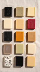 Fototapeta premium Artisanal Soap Collection: Captivating assortment of handcrafted artisanal soap, each square bar boasting unique color and texture, arranged on a neutral linen background