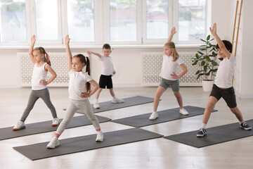Obraz premium Group of children practicing yoga on mats in class