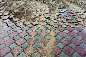 Washed-out paving slabs in sand after a flood.