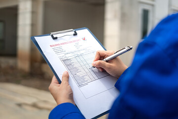 A construction foreman is checking on building quality checklist report during inspecting at the...