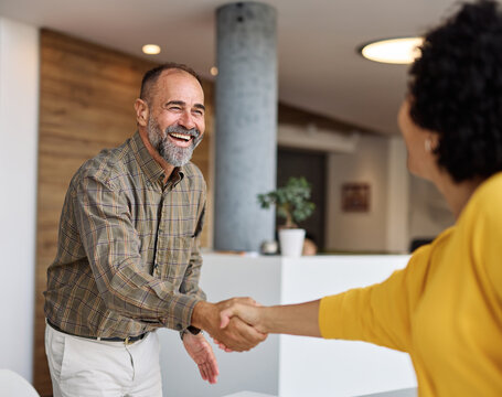 Group of businesspeople having a meeting shaking hands handshake introducing each other and applauding during meeting in the office. Teamwork and success concept, portrait of a middle aged mature bus