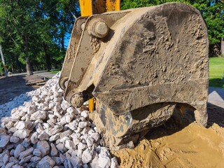 A large piece of equipment is sitting on a pile of rocks. The equipment is dirty and has a lot of...