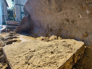 A large piece of machinery is sitting on a pile of dirt. The dirt is brown and the machine is large...
