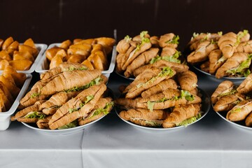 Multiple croissants with ham, cheese, and greens filling served on plates