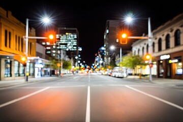 Blurred night city street view.  City buildings, streetlights, and traffic signals visible in the background. 