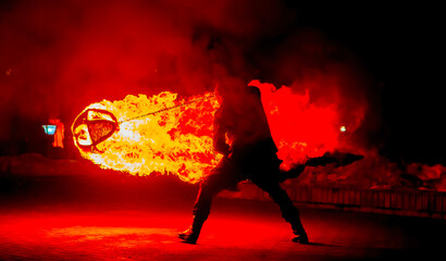 Fire performer demonstrates skillful control of flaming poi during nighttime outdoor event