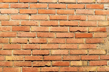 Brick wall texture featuring a weathered pattern with varying shades of brown and orange in natural...