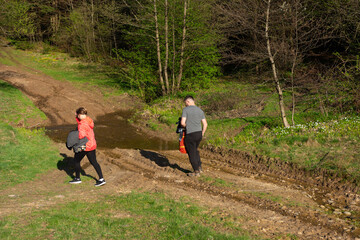 Obraz premium Exploring the serene trails of a lush forest during a sunny afternoon in spring, two friends embark on a nature walk beside a gentle stream