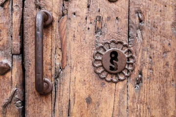 Old wooden door with wrought iron lock and trim ornaments