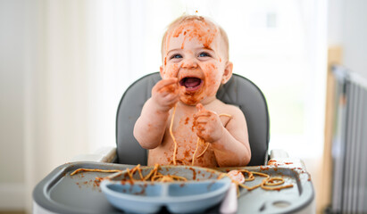 Little baby eating her dinner and making a mess