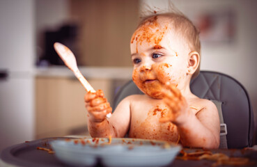 Little baby eating her dinner and making a mess