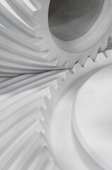 Two white bevel gears, part of crossed gear transmission