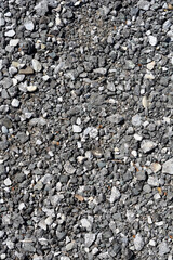 An overhead close-up shot reveals a textured surface composed of various shades of gray and white gravel