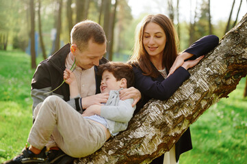 happy family enjoying nature together in park. father, mother, and child share joyful moment...