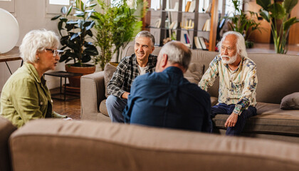 Senior friends enjoying time together and having conversation in the living room